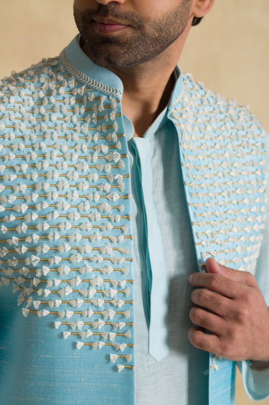 Man wearing a light blue ethnic jacket with textured embroidery details