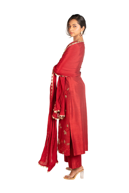 Woman in red embroidered kurta set with dupatta, clear heels, white background
