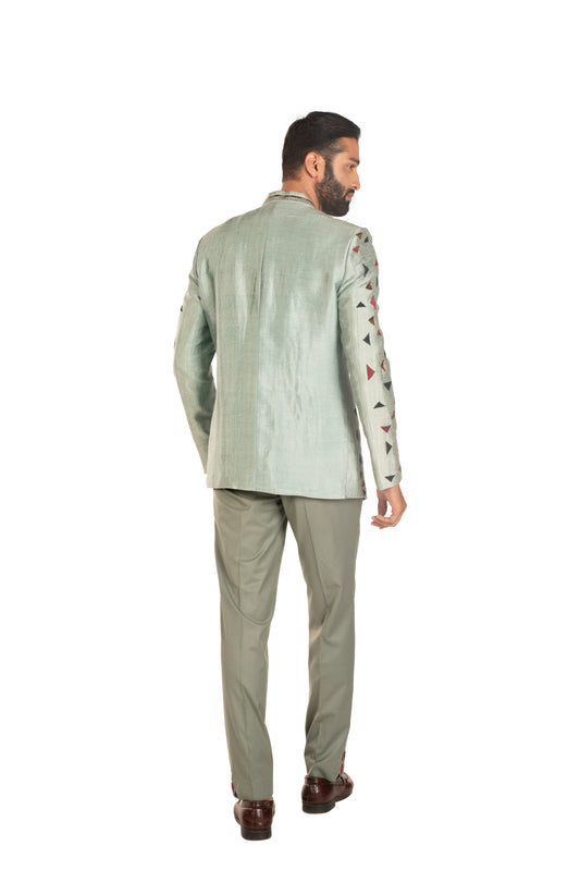 Man modeling light green suit with geometric sleeve details, back view, on white background