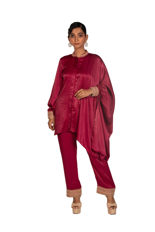 Woman in magenta silk asymmetric kurta set with beaded cuffs and pants, studio background